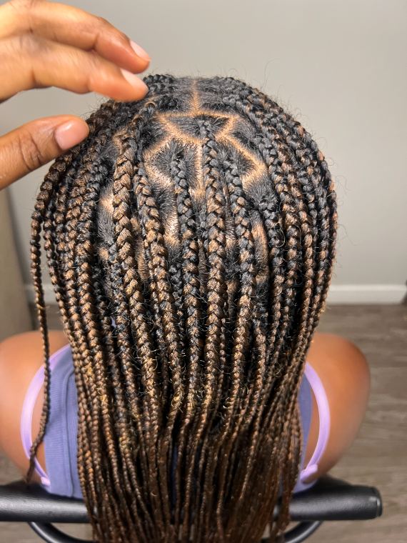Overhead view of copper knotless braids with a star-shaped part pattern