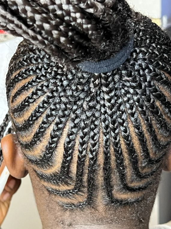 Radiating cornrow pattern at the nape gathered into a bun