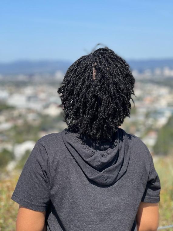 Short locs photographed against the Los Angeles skyline